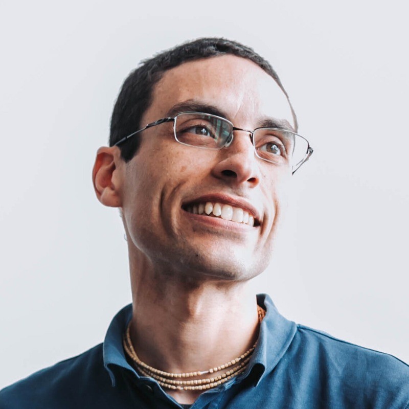 Keynote's headshot, image of a smiling man with black hair and glasses
